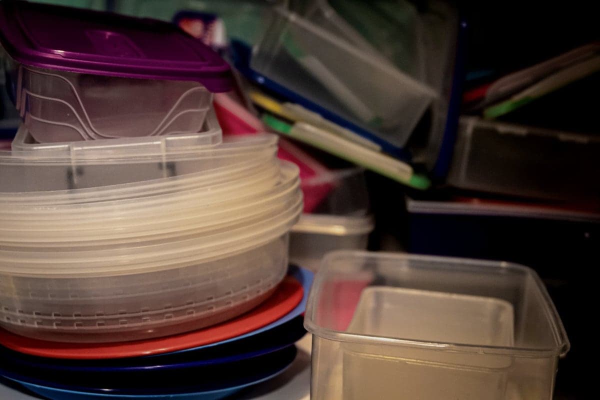 Stacked plastic storage bins with lids in a garage