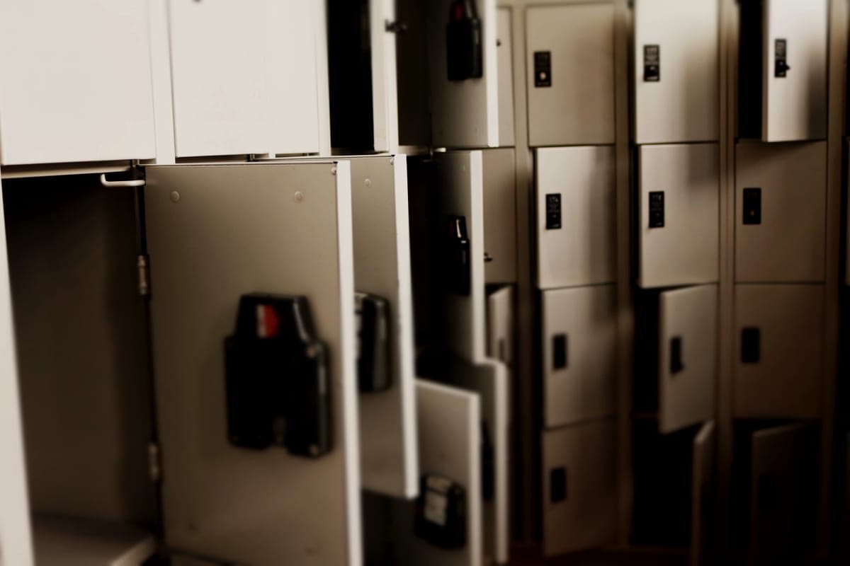 A row of gray steel lockers with lockable doors standing open