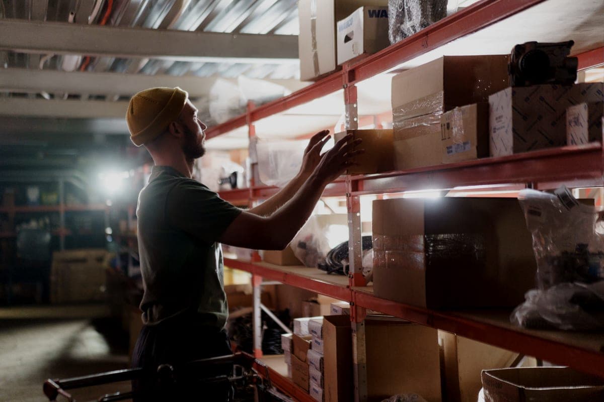 Boxes and cases stored high on steel racking under a roof