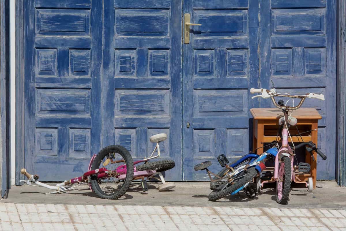 Children's bikes, scooters and toys in a garage