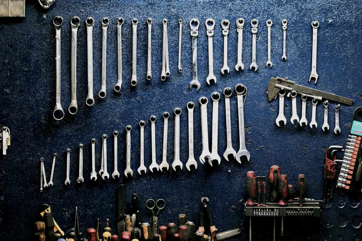 Hand tools hanging from hooks on a workshop wall
