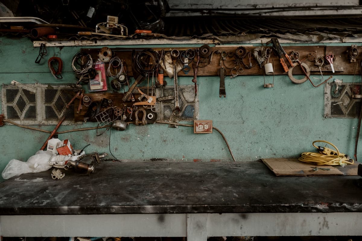 Tools hung on a rail along a workshop wall above a bench