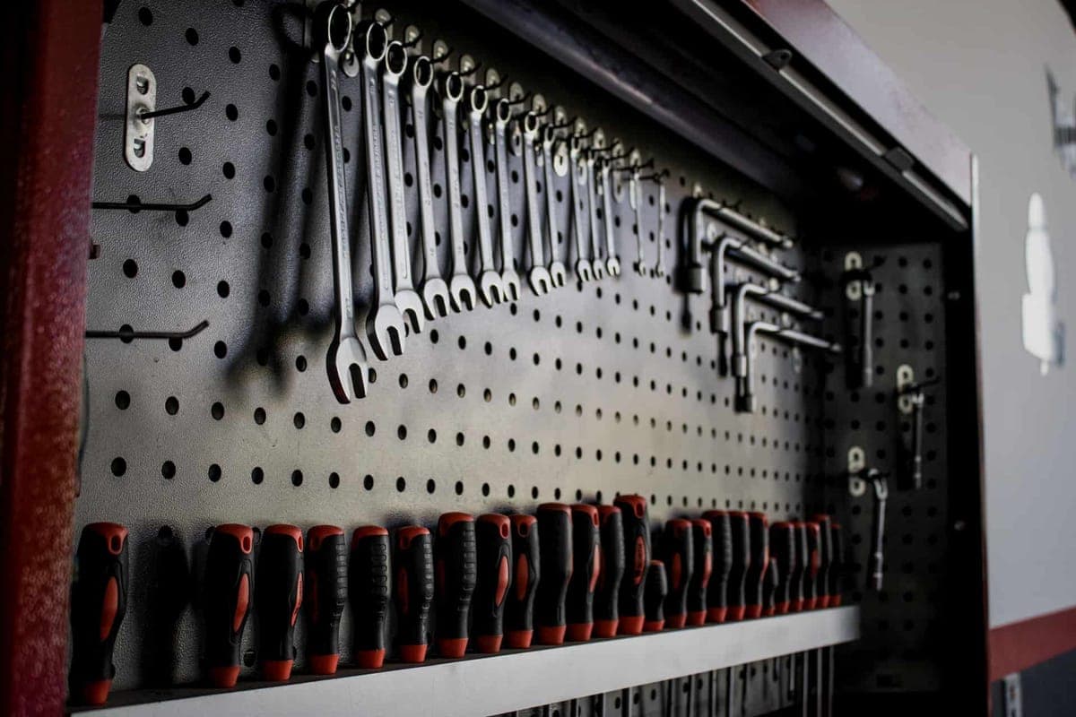 A pegboard with hooks and tool positions marked out on the panel