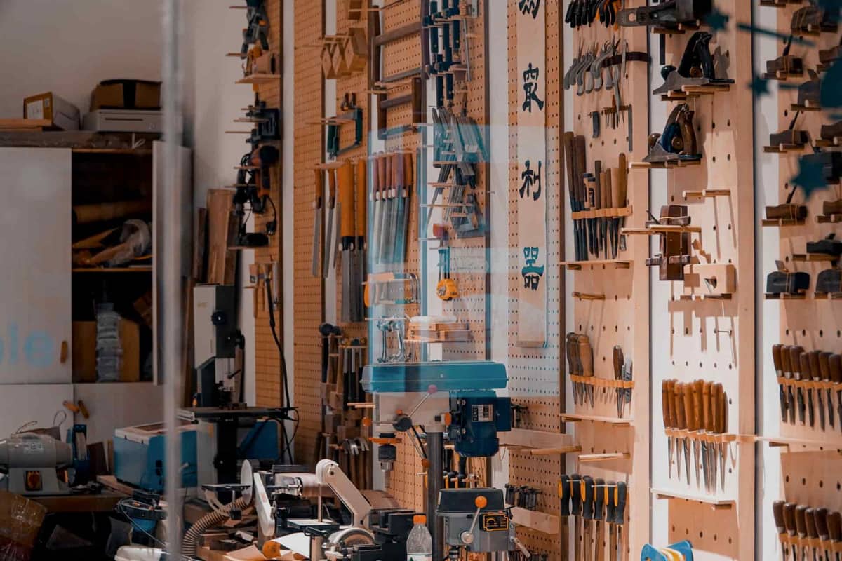 A pegboard wall in a workshop with hand tools hanging on hooks