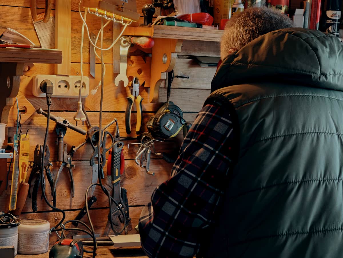 A person working in a paneled workshop surrounded by tools