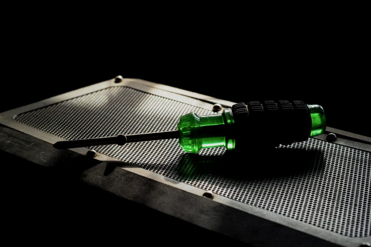 A perforated metal tool board holding hand tools in a workshop